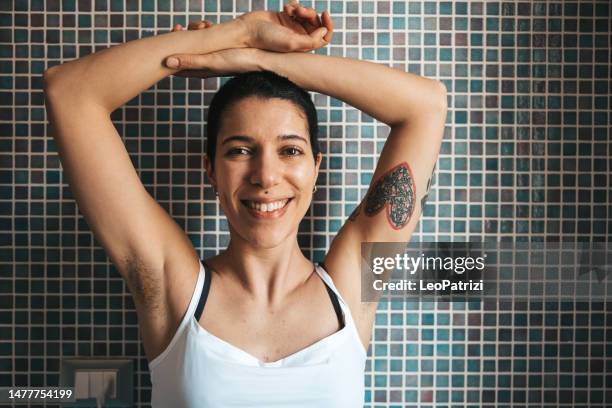 young woman portrait showing armpit hair - armpit woman stockfoto's en -beelden