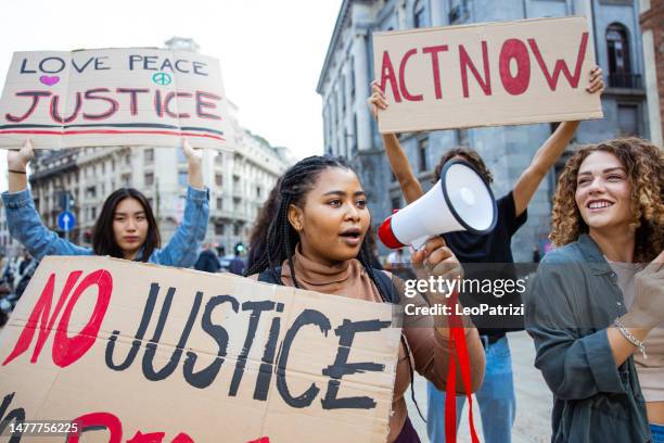 group of people on a protest marching in the city streets - protestor crowd stock pictures, royalty-free photos & images