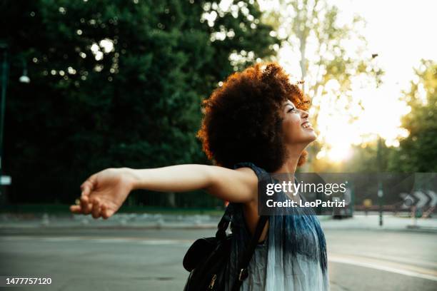 happy woman with arms outstretched breathing fresh hair - black history month stock pictures, royalty-free photos & images