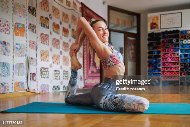 female yoga instructor stretching on mat and preparing for class - upright position stock pictures, royalty-free photos & images