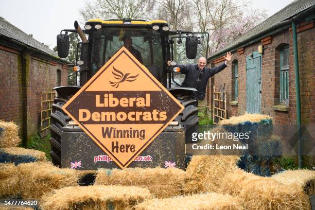 Leader of the Liberal Democrat Party Ed Davey poses for photos after driving a tractor through a pile of hay bales to promote the launch of the local...