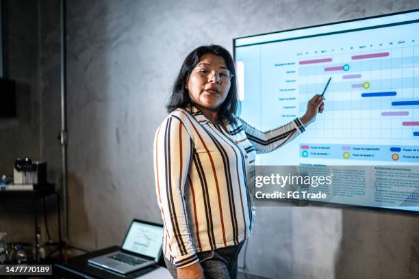 geschäftsfrau, die eine präsentation im büro macht - bolivianischer abstammung stock-fotos und bilder