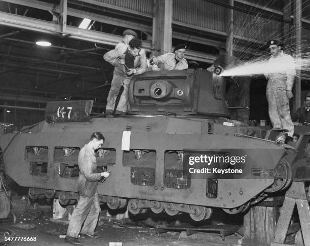 Factory workers fitting out the turret of a Matilda II MkIII tank in preparation for shipment to the Soviet Union circa December 1941 at the Ruston &...