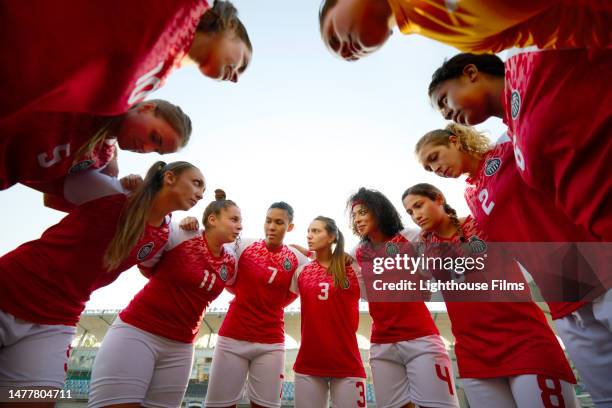 low angled shot of a huddle with competitive women soccer players - fußballtrikot stock-fotos und bilder