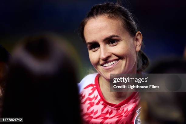 mcu smiling female soccer player looks towards teammates during pregame huddle - football player face stock pictures, royalty-free photos & images