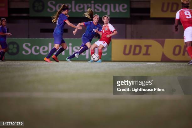 strong woman soccer forward passes to her teammate at the top of the penalty box - international race stock pictures, royalty-free photos & images