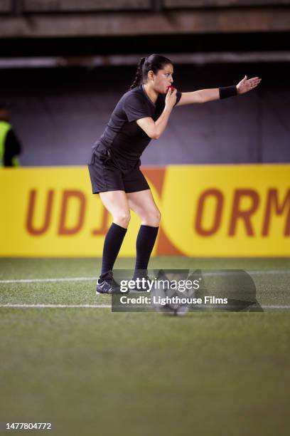 professional female soccer referee blows her whistle to signal a free kick - penalty spot football stock pictures, royalty-free photos & images