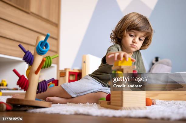 boy learning while playing at home with toys - montessori education stock pictures, royalty-free photos & images