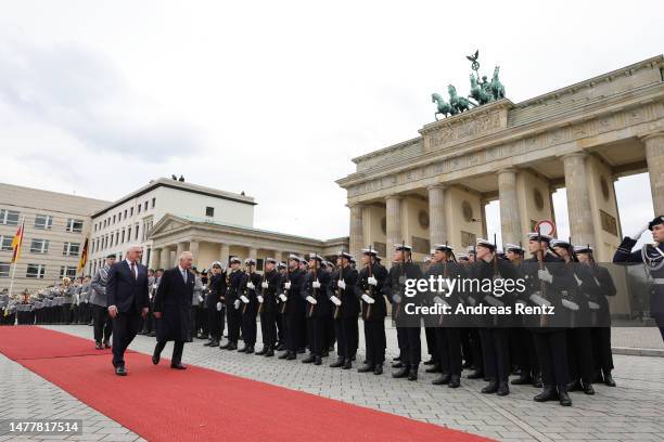 German President Frank-Walter Steinmeier and King Charles III walk together in front of the military Guard of Honour and Brandenburg Gate during the...