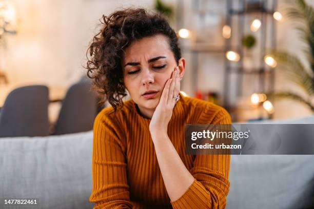 young woman having toothache at home - toothache stock pictures, royalty-free photos & images