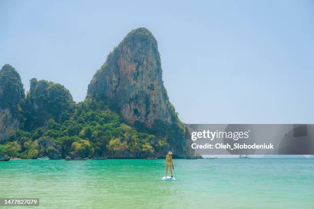 woman sup boarding on railey beach in thailand - phuket province stock pictures, royalty-free photos & images