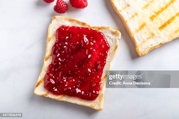 open sandwich with toast and raspberry jam - preserves stockfoto's en -beelden