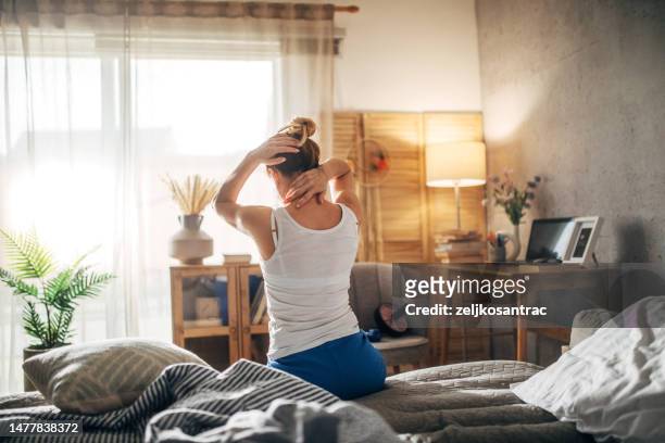woman in bed having backache - back pain bed stock pictures, royalty-free photos & images