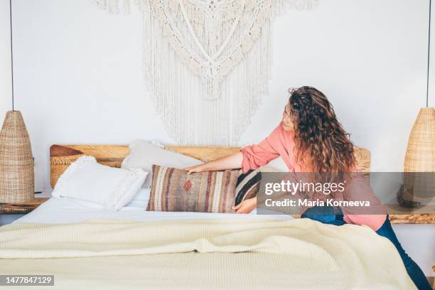 woman doing her morning routine, making bed at home. - arranging pillow stock pictures, royalty-free photos & images