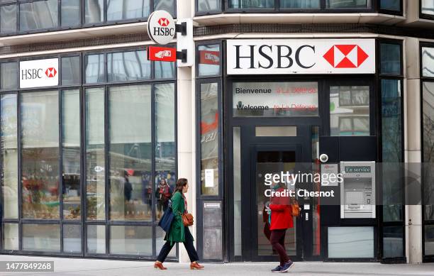 Women walk past a branch of HSBC bank on March 29, 2023 in La Defense near Paris, France. Societe Generale, BNP Paribas, Exane, Natixis and HSBC were...