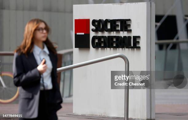 An employee walks past the logo of French bank Societe Generale at the headquarters building on March 29, 2023 in La Defense near Paris, France....