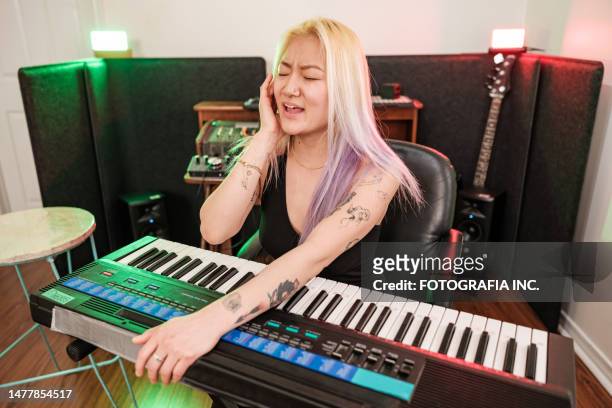 female korean musician practising at home recording studio - electric piano stock pictures, royalty-free photos & images