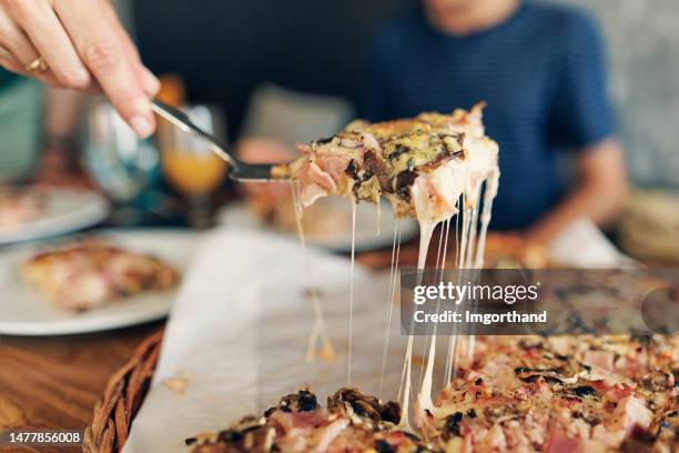 famiglia che gusta la pizza a pranzo - lunch cheese foto e immagini stock