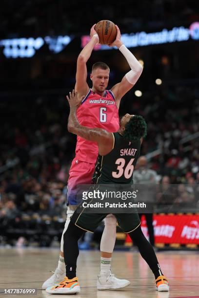 Kristaps Porzingis of the Washington Wizards is guarded by Marcus Smart of the Boston Celtics during the second half at Capital One Arena on March...