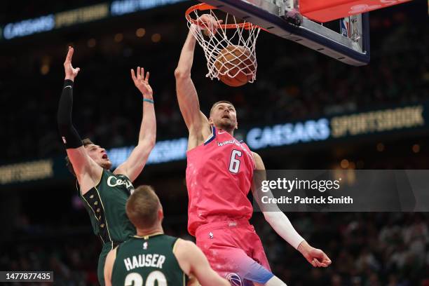 Kristaps Porzingis of the Washington Wizards dunks against the Boston Celtics during the second half at Capital One Arena on March 28, 2023 in...