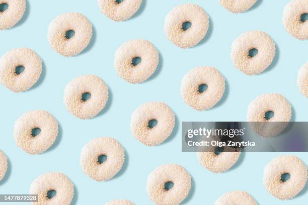 white donuts pattern on light blue background. - blue donut white background stock pictures, royalty-free photos & images