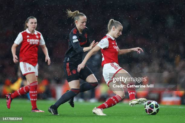 Leah Williamson of Arsenal runs with the ball whilst under pressure from Lea Schueller of FC Bayern Munich during the UEFA Women's Champions League...