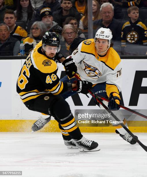 David Krejci of the Boston Bruins is pursued by Egor Afanasyev of the Nashville Predators during the first period at the TD Garden on March 28, 2023...