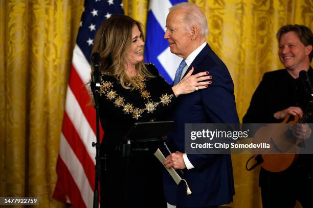 President Joe Biden thanks actor Rita Wilson after she sang four songs during a reception celebrating Greek Independence Day in the East Room of the...