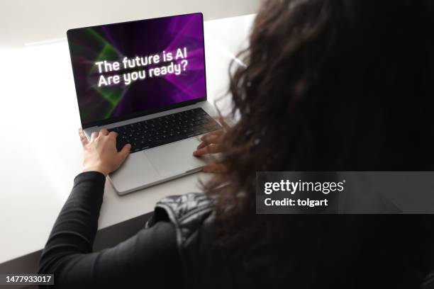 woman using laptop with artificial intelligence screen - fake advertisement stock pictures, royalty-free photos & images