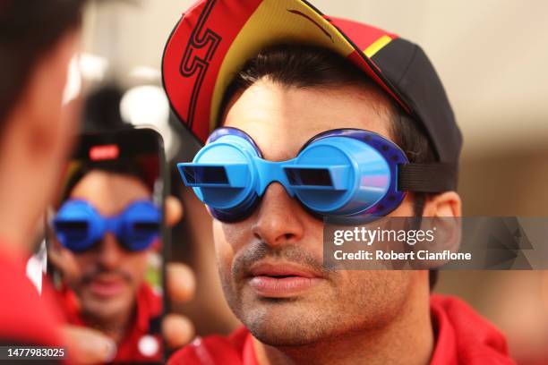 Carlos Sainz of Spain and Ferrari wears goggles as he prepares to play swingball in the Paddock during previews ahead of the F1 Grand Prix of...