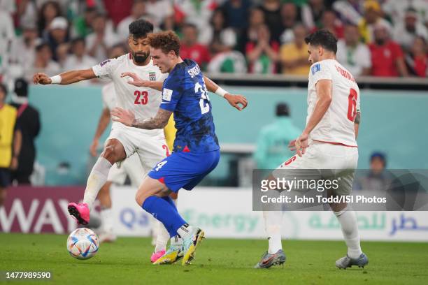 Ramin Rezaeian of Iran battles with Josh Sargent of the United States during a FIFA World Cup Qatar 2022 Group B match between Iran and USMNT at Al...