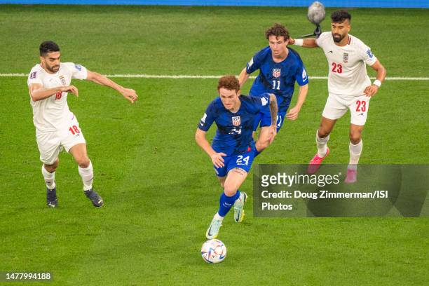 Josh Sargent of the United States dribbles the ball while Brenden Aaronson of the United States, Ali Karimi and Ramin Rezaeian of Iran look on during...