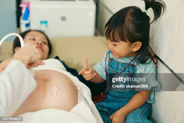 asian baby girl enjoy and was happy to see doctor used an ultrasound sonogram  monitor for  the fetus 34 weeks her mother pregnant - 20 week foetus stock pictures, royalty-free photos & images