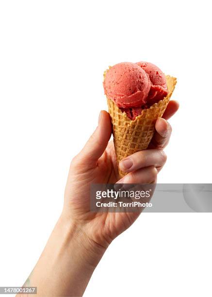 scoop of strawberry ice cream in homemade waffle ice cream cone in hand isolated on white - ice cream cone stockfoto's en -beelden