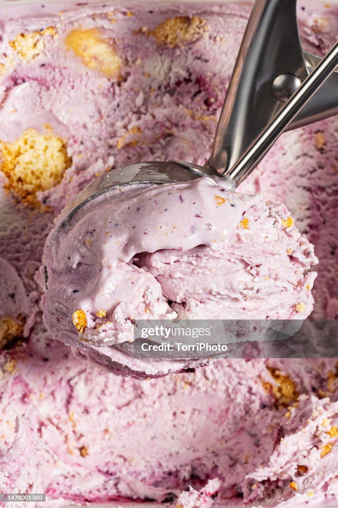 Scoop of berry gelato ice cream with jam and biscuits, close-up