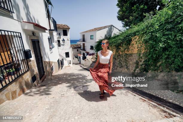 teenager girl walking in charming old town streets of altea in spain - spaanse cultuur stockfoto's en -beelden