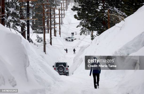 Road is lined with snowbanks piled up from new and past storms, after yet another storm system brought heavy snowfall further raising the snowpack on...