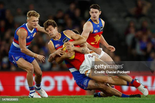 Josh Dunkley of the Lions is tackled by Tom Liberatore of the Bulldogs during the round three AFL match between Western Bulldogs and Brisbane Lions...