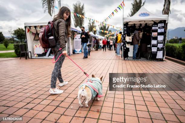 young woman walking with her dog on a public park - festival of arts celebrity benefit event stockfoto's en -beelden