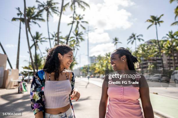 two female friends walking in the broadwalk - maceió imagens e fotografias de stock