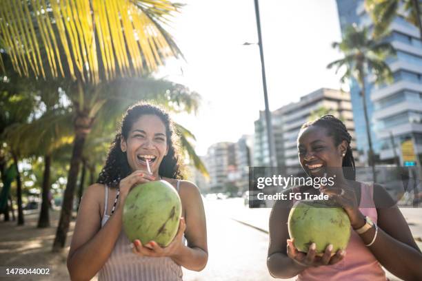 ココナッツウォーターを飲む遊歩道を歩く友達 - 2 coconut drinks ストックフォトと画像