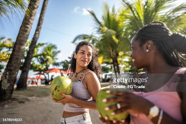 ココナッツウォーターを飲む遊歩道を歩く友達 - 2 coconut drinks ストックフォトと画像