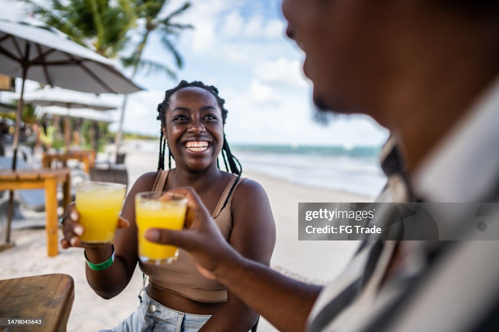 Mid adult couple doing a celebratory toast in a restaurant at the beach