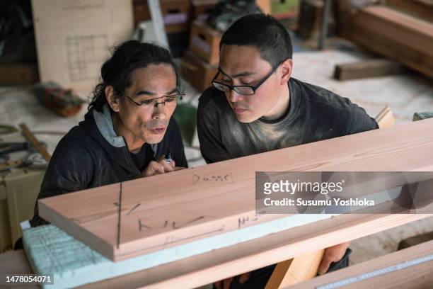 young carpenters work by hand in the workshop to process lumber for home construction. - cryptomeria japonica stock pictures, royalty-free photos & images