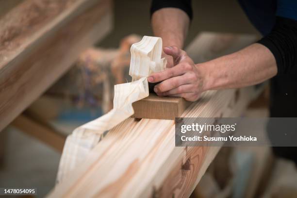 young carpenters work by hand in the workshop to process lumber for home construction. - carpenteria foto e immagini stock