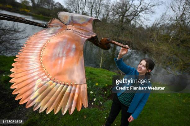 Rebecca Buley poses with 'Heron' by Ted Edley, on March 30, 2023 in Pallington, United Kingdom. FORM: The Sculpture Show 2023 brings together work by...