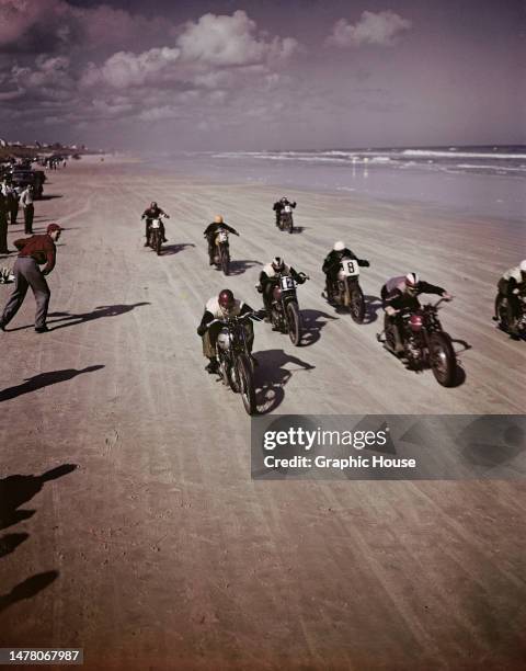 The chequered flag is waved as motorcycles race, with the shoreline in the background, across the compacted sands of Daytona Beach, in Daytona,...