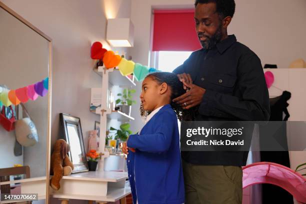 a father helping his young daughter get ready for school - parent daughter school uniform stock pictures, royalty-free photos & images