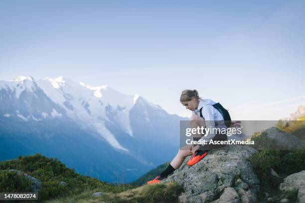 un coureur de trail noue un lacet de chaussure sur un col de montagne - cordon photos et images de collection