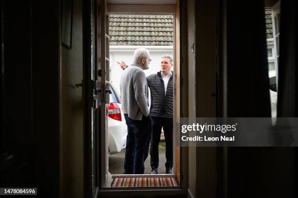 Labour Party leader Keir Starmer speaks with a resident as he delivers leaflets following the launch of Labour's Local Election campaign on March 30,...